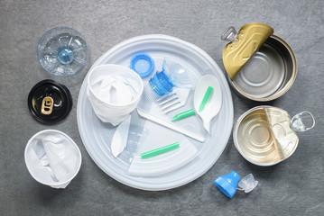 Plastic waste of plastic dishes on the table flat lay background.