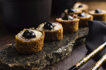 Traditional salmon fish hot roll with tare sauce  in a rustic granite platter in wood background