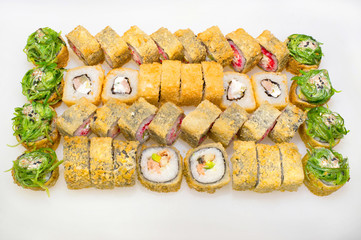 Tempura Japanese roll set with rice, cream cheese, nori, salmon, seaweed, avocado, caviar on a white background