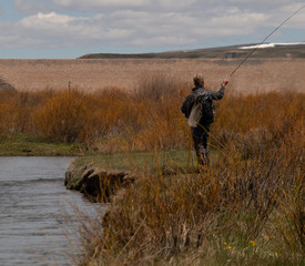 A man fly fishing on a western trout stream.