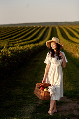 Obraz premium Woman holding fruit basket in front of currant field.