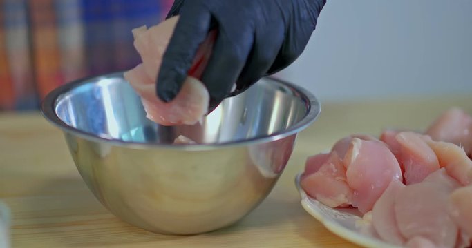 Pieces of raw meat are put in a bowl. Fresh meat is poured with white sauce, the cooking process. Meat is pickled in white sauce, close-up.