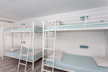 Clean bedroom with bunk beds in a hotel, a hostel for tourists. - obrazy, fototapety, plakaty