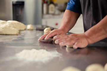 Detail of male hands preparing bread dough - baked wheat bread - Happy Hispanic adult man preparing bread dough