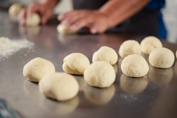 Fototapeta na wymiar Detail of ready to bake bread dough - Male hands preparing dough - baked wheat bread