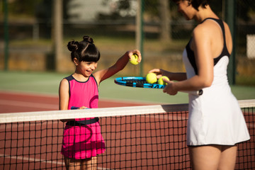 une mère et sa fille passant un moment agréable au tennis