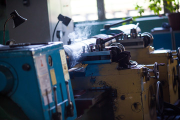 Close-up. A milling machine cuts a metal part. Steaming steel part on the machine.