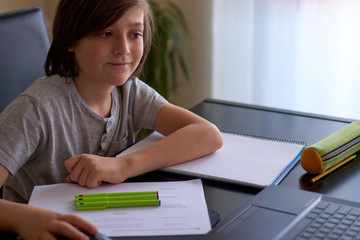 Boy in front of the computer studying at home
