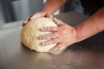 Male hands preparing dough - baked wheat bread - grandfather is kneading a dough for cooking bread - baker's hands