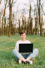 woman emotion laptop sits grass meadow forest