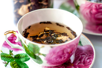 Cup of tea. Large tea leaves in a Cup. A can of tea. Large-leaf tea with fruit. 