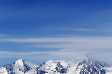 Fototapeta na wymiar High snowy mountains and blue sky with clouds