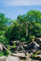 Fototapeta na wymiar Sofia Park, Uman. Large stones among tall old trees. Stones in a landscape park on a summer day. National landscape park.