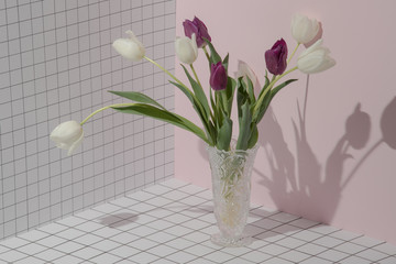 Bouquet of colored tulips on a checkered pink background. Concept template nature blog, social media, flowers concept. Conceptual art minimalistic photography. Copy space