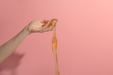 Sugar paste in hand on pink background. Concept epilation. Copy Space