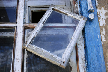 Old window with a wooden frame, in an abandoned rural house.