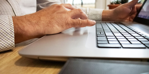 A man works at a computer. The male hand is located on touch screen.