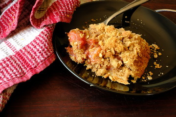 One slice of strawberry rhubarb pie with crumb topping