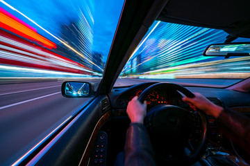 Movement of the car at night at high speed view from the interior with driver hands on wheel....