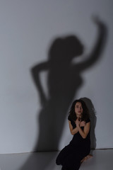Young woman and shadow on the wall
