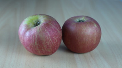 Dos manzanas juntas sobre una mesa de madera