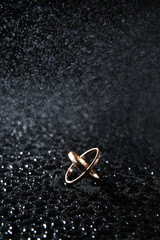 Golden wedding rings on a black background with drops spray