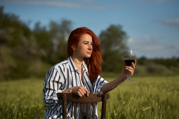 Young beautiful woman drinking wine outdoors.