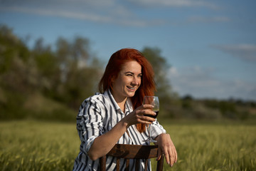 Young beautiful woman drinking wine outdoors.