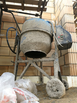 Cement mixer in front of building block wall