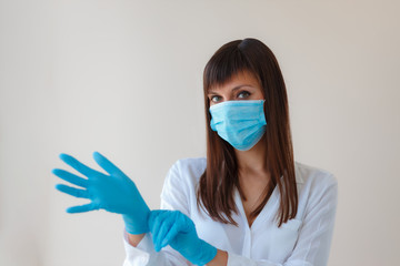 Caucasian young woman wearing protective respiratory mask and using protective gloves for prevent infection. Medical concept protection from outbreak Covid 19 virus, cold, flu, respiratory disease.