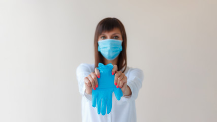 Caucasian young woman wearing protective respiratory mask and using protective gloves for prevent infection. Medical concept protection from outbreak Covid 19 virus, cold, flu, respiratory disease.