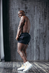 Profile Strong and muscular african american with naked top and black shorts smiling at the camera