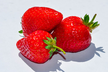 Red bright fresh strawberry closeup on the white background. Isolated berry, berry shadow.