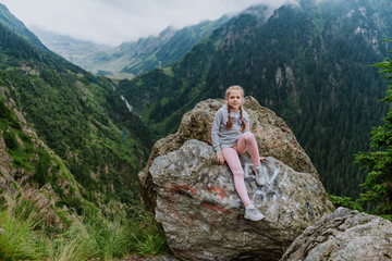 Naklejka na ściany i meble Girl on the cliff edge near Transfegerasan mountain road.