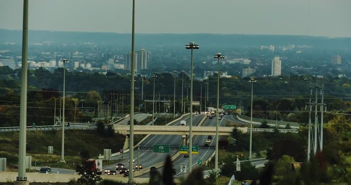 Day to night sunset time-lapse on top of Hamilton mountain facing the city of Hamilton Ontario, Canada and highway 6, with a couple fall colored trees in the foreground.