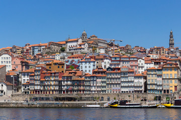 Fototapeta na wymiar Colorful houses of Porto Ribeira, traditional facades, old multi-colored houses with red roof tiles on the embankment in the city of Porto, Portugal. Unesco World Heritage.