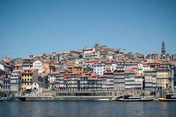 Fototapeta na wymiar Colorful houses of Porto Ribeira, traditional facades, old multi-colored houses with red roof tiles on the embankment in the city of Porto, Portugal. Unesco World Heritage.