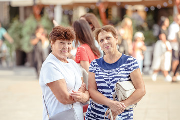 Mature Female Friends Socializing In Backyard Together.