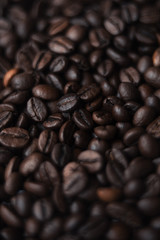 Fototapeta premium Coffee beans in blur with focuses in the middle. background for the desktop in the coffee industry, top view. dark roasted coffee.