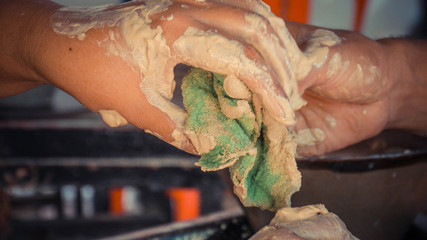 Dirty smudge hands holding a green wool cloth