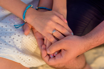 Man and woman newlyweds hold hands close-up.