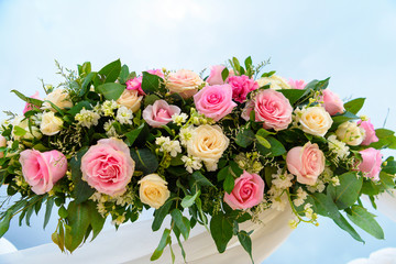 Scenery of flowers of white and pink roses on a wedding arch.