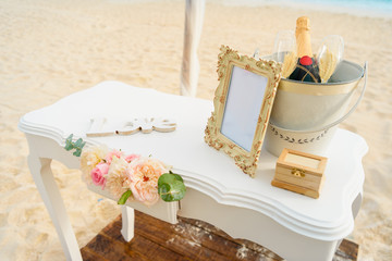 Fototapeta na wymiar White table for a wedding ceremony with decorations on the seashore.
