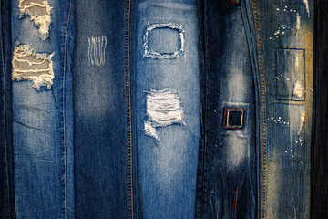 Torn Denim jeans pants collection. Lots of ripped blue trousers. Trendy fashion design background 