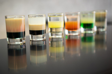beautiful photo of many different alcoholic shots prepared by a bartender at the bar