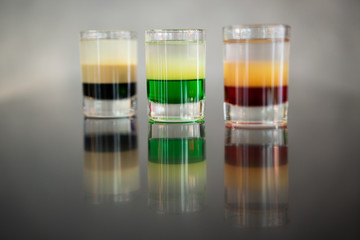 beautiful photo of many different alcoholic shots prepared by a bartender at the bar
