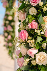 Scenery of flowers of white and pink roses on a wedding arch.