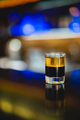 beautiful photo of an alcoholic shot prepared by a bartender at the bar