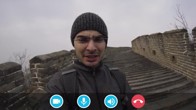 Man using a viideo calling mobile app with icons, to chat and have a conversation outside while walking around