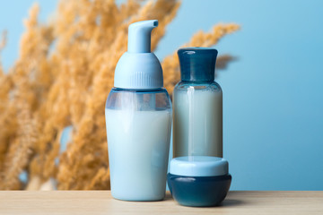 Blue cosmetic bottles set and jar with natural organic cream. Beauty product packages collection, blank templates of transparent containers, packaging design